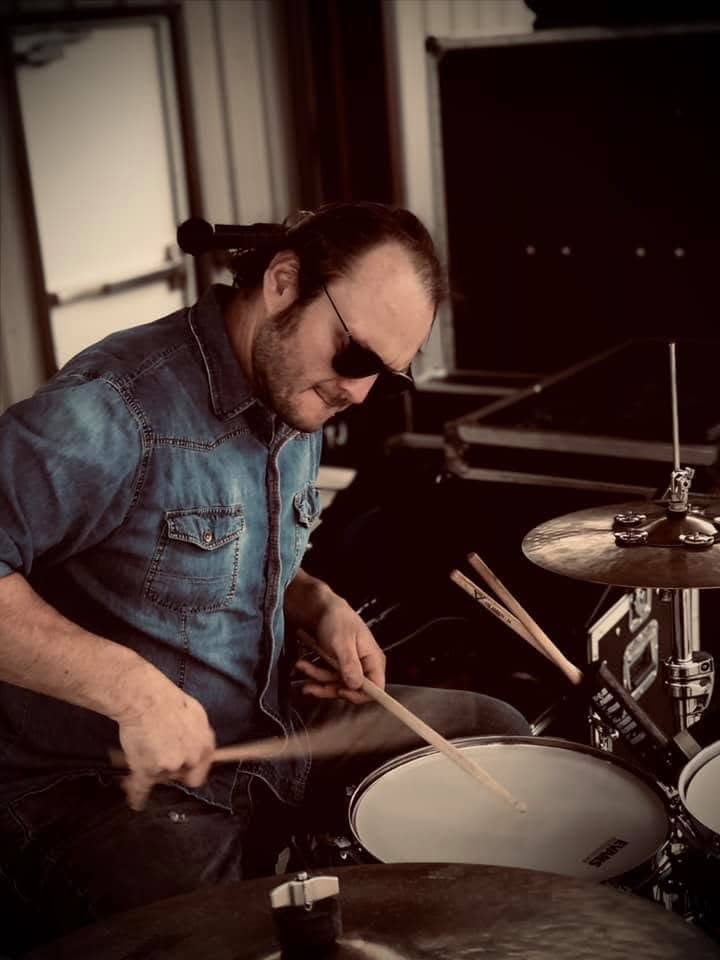 Nate Kelley seated behind a drum kit during a performance